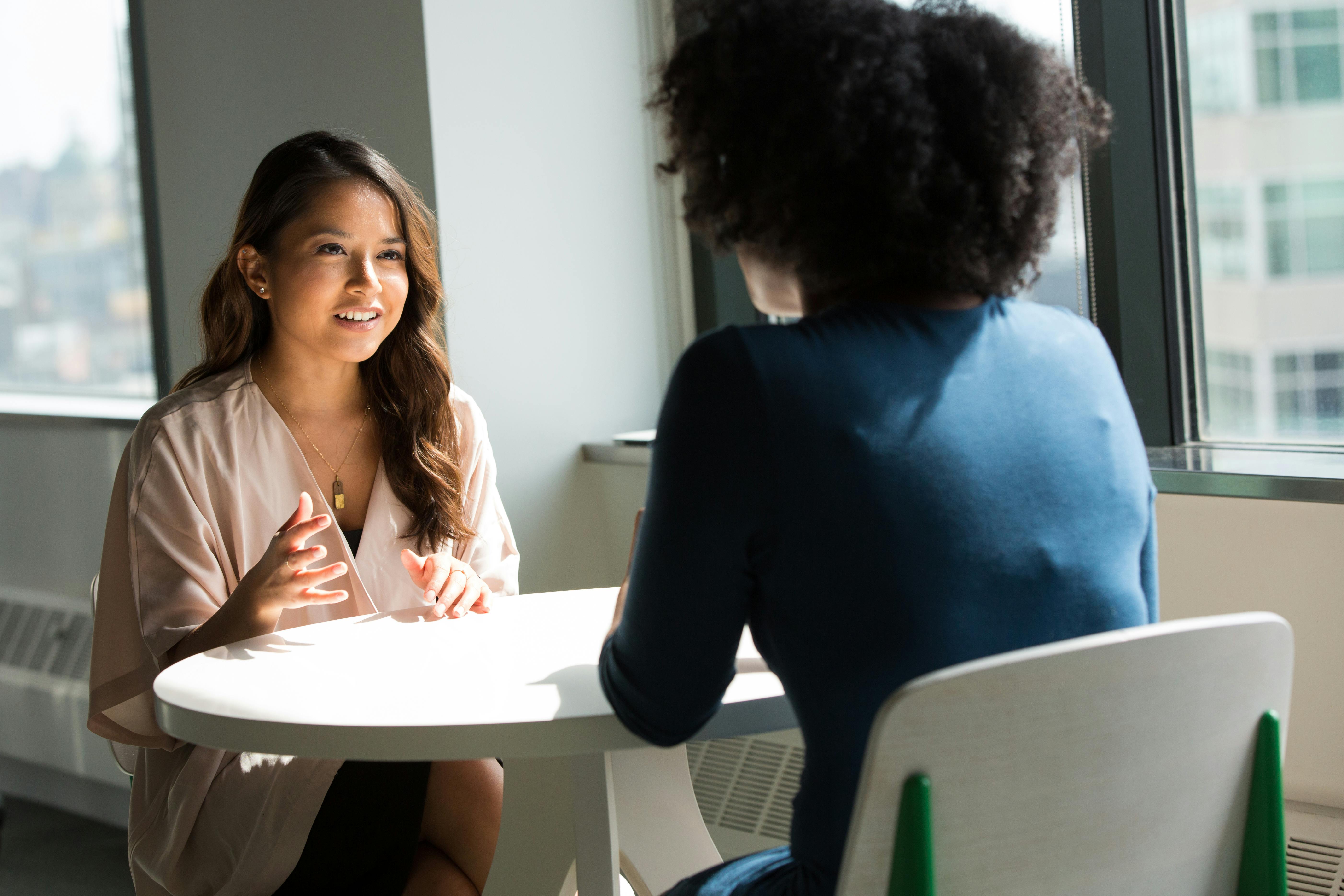 A therapist and client engaged in a supportive conversation, demonstrating therapeutic alliance in a modern office setting